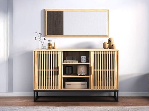 黒の金属脚付きのルーバー扉の木製キャビネット。上には装飾アイテムが置かれ、スタイリングされた部屋に設置されています。コレクションの商品を見るにはクリックしてください。