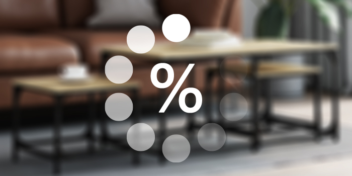 室内のリビング空間に、ぼやけたブラウンのソファとコーヒーテーブルがあり、その上に読み込み中の白い割引マークが表示されています。