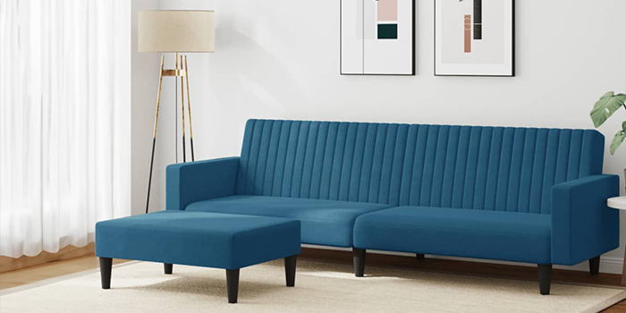 リビングルームに孔雀ブルーの2人掛けソファと同色系のオットマン。ソファの背後の壁には2枚の装飾画が掛けられ、横にはフロアランプが置かれている。クリックして新商品をもっと見る。